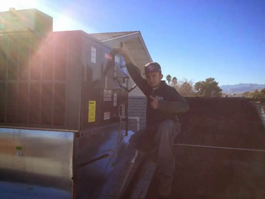 HVAC technician performing Boiler Repair on a rooftop unit in Mitchell